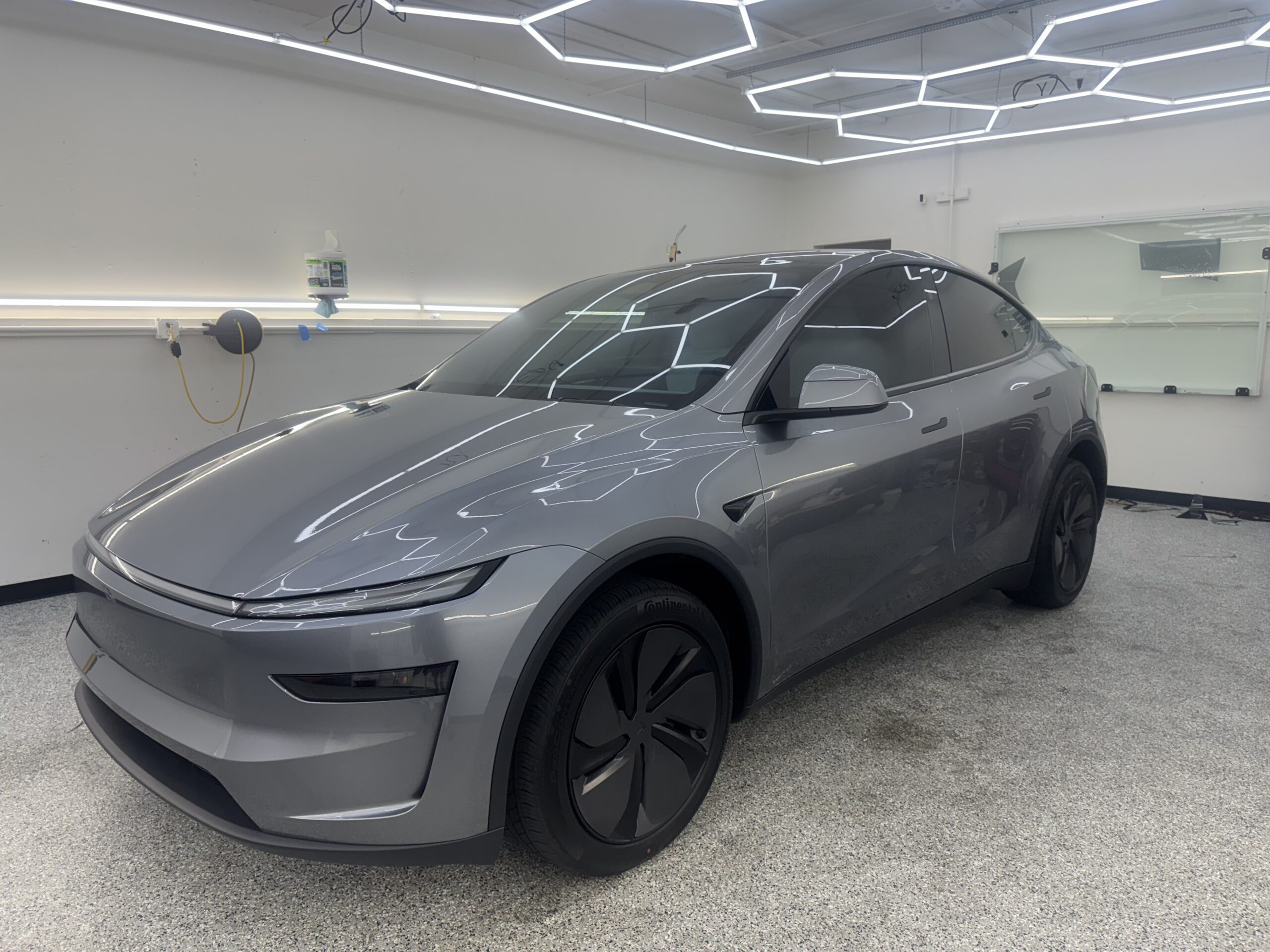 Gray Tesla Model Y with ceramic window tint showing panoramic roof at Tru-Tints